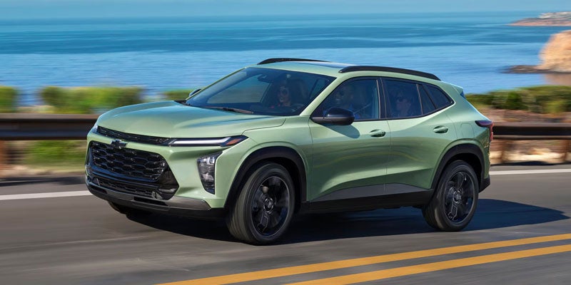 A green Chevy Trax driving on the coastline highway.
