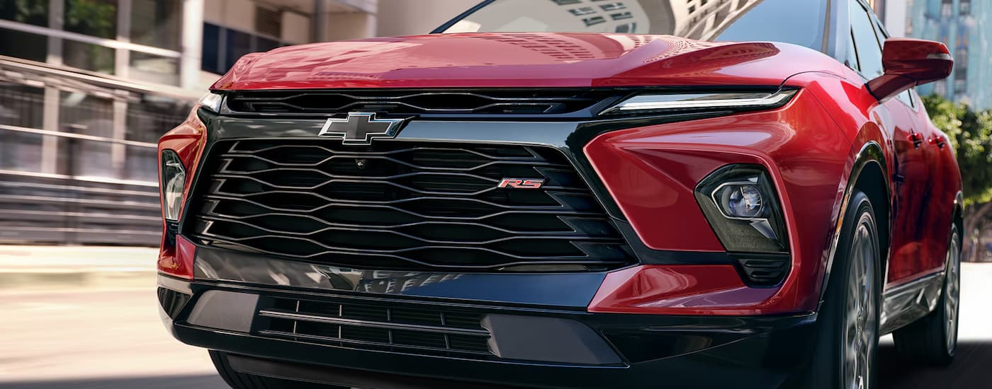 Close-up on the grille and badge of a red 2026 Chevy Blazer.