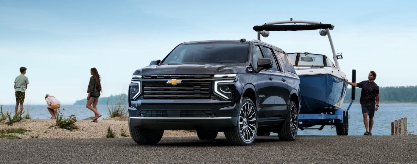 Black 2025 Chevy Suburban High Country parked near a lake