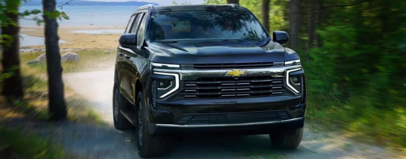 Black 2026 Chevy Tahoe driving away from a beach