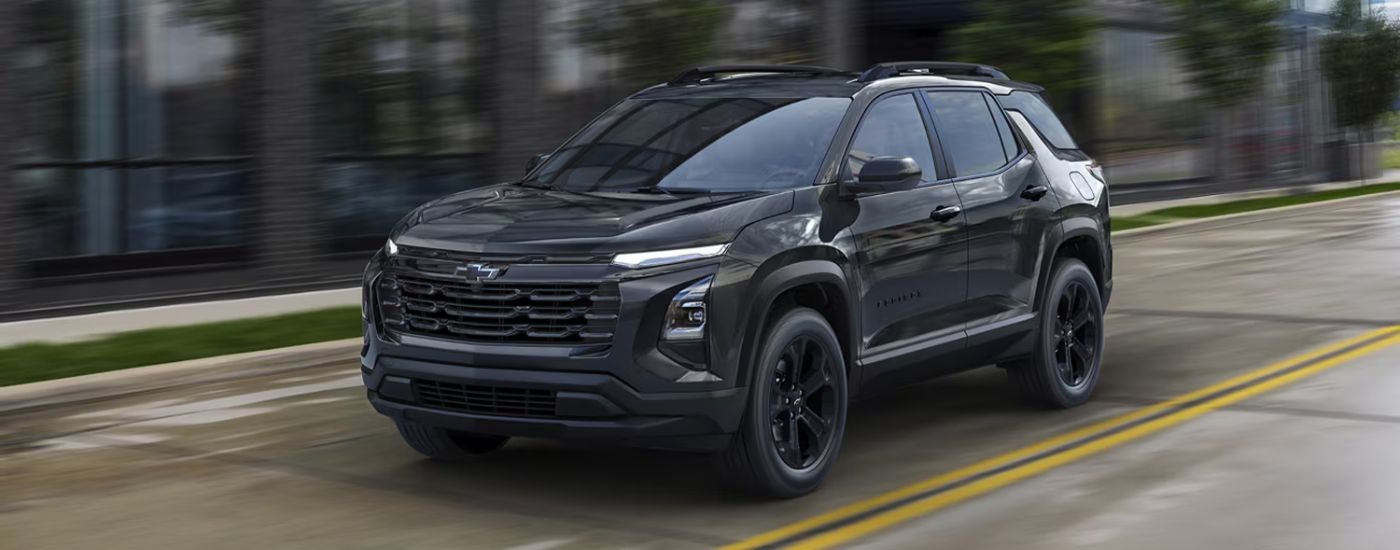 Black 2026 Chevy Equinox driving on a city street.