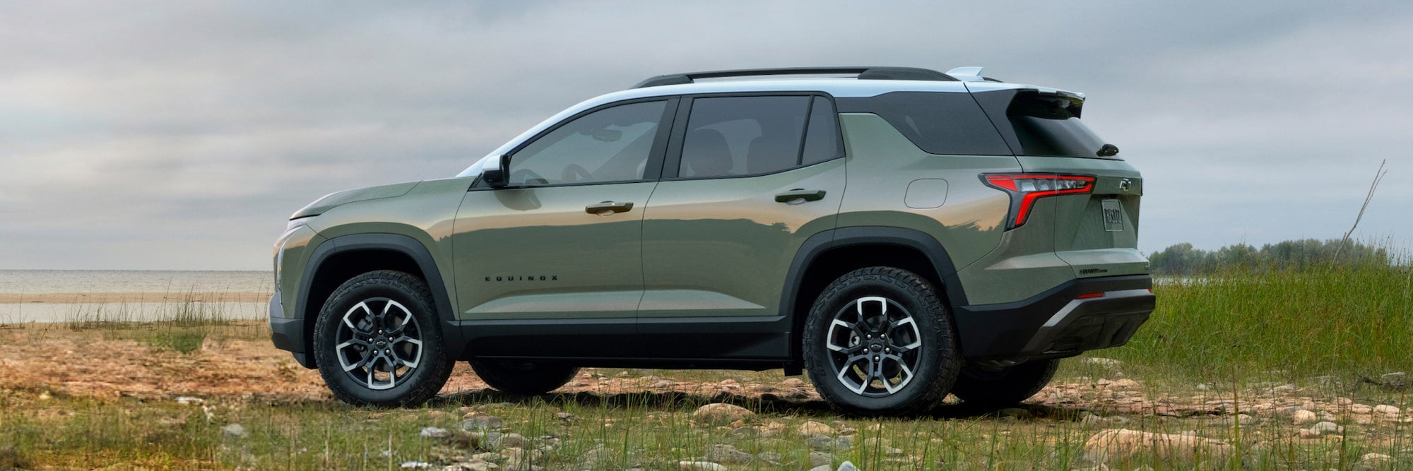 Side of a green 2026 Chevy Equinox parked off-road.