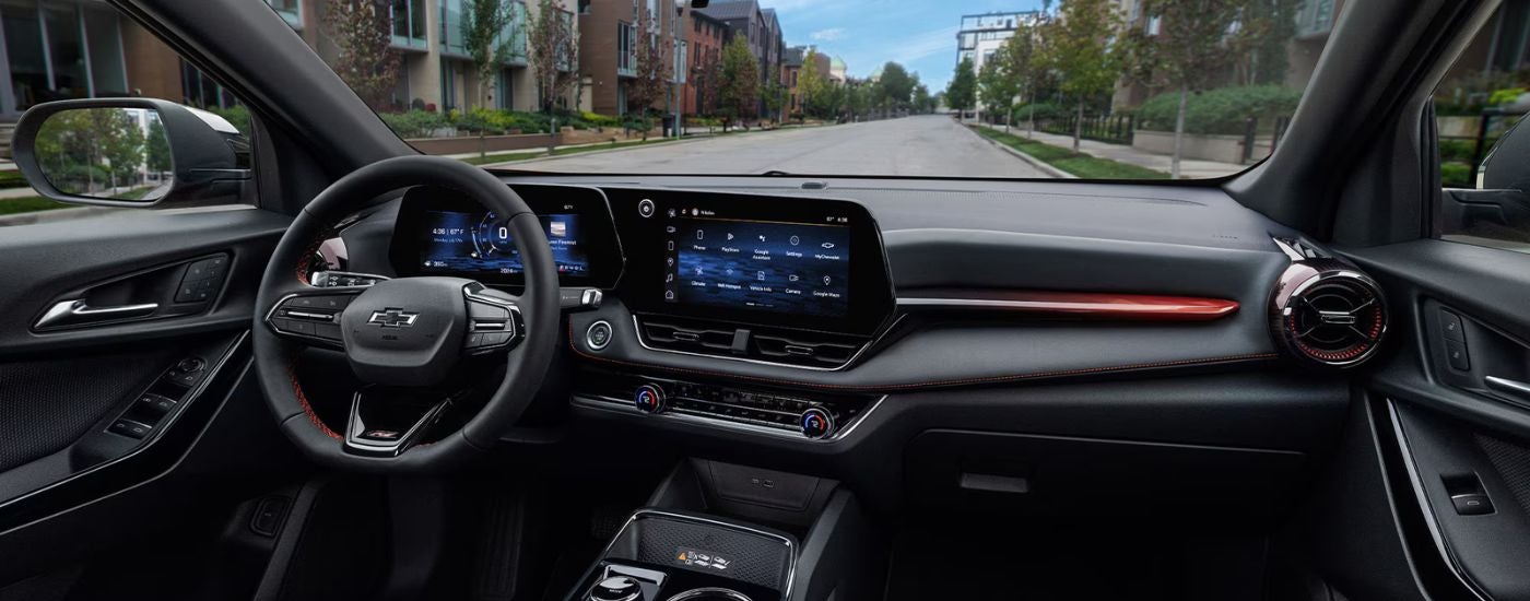 2026 Chevy Equinox black front interior showing the steering wheel and infotainment.