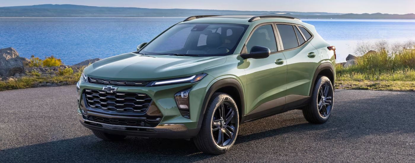 A green 2026 Chevy Trax parked by a lake.