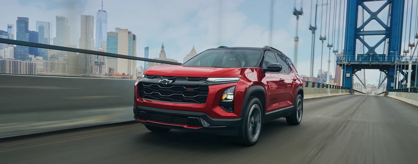 Red 2027 Chevy Equinox driving across a bridge