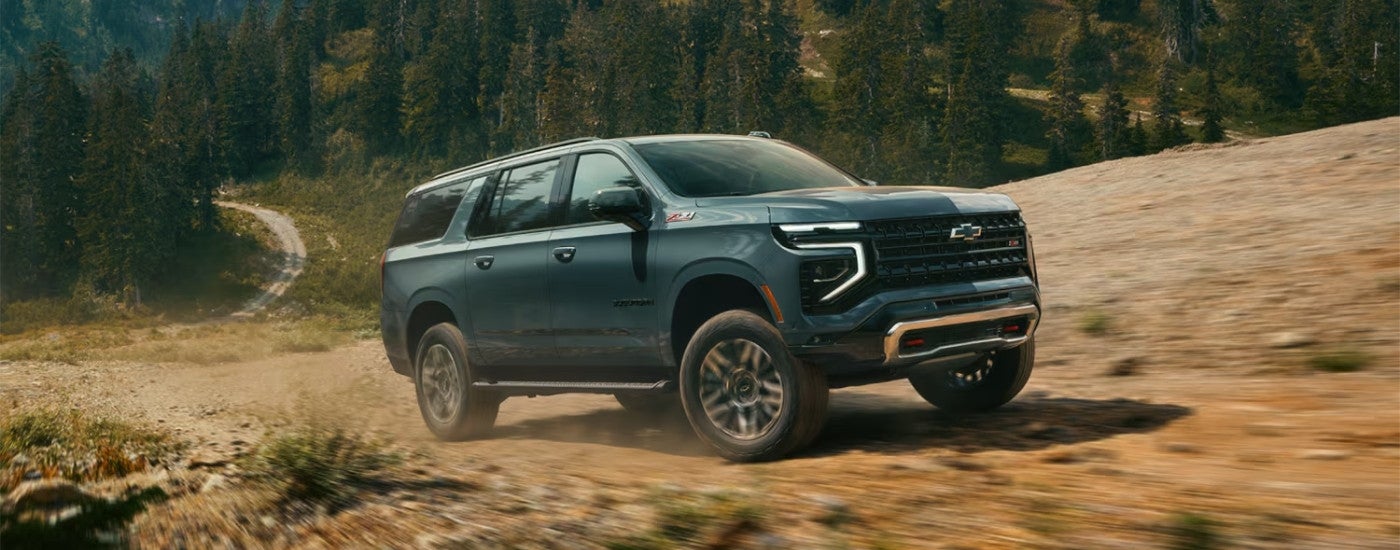 A green 2025 Chevy Suburban Z71 off-roading.