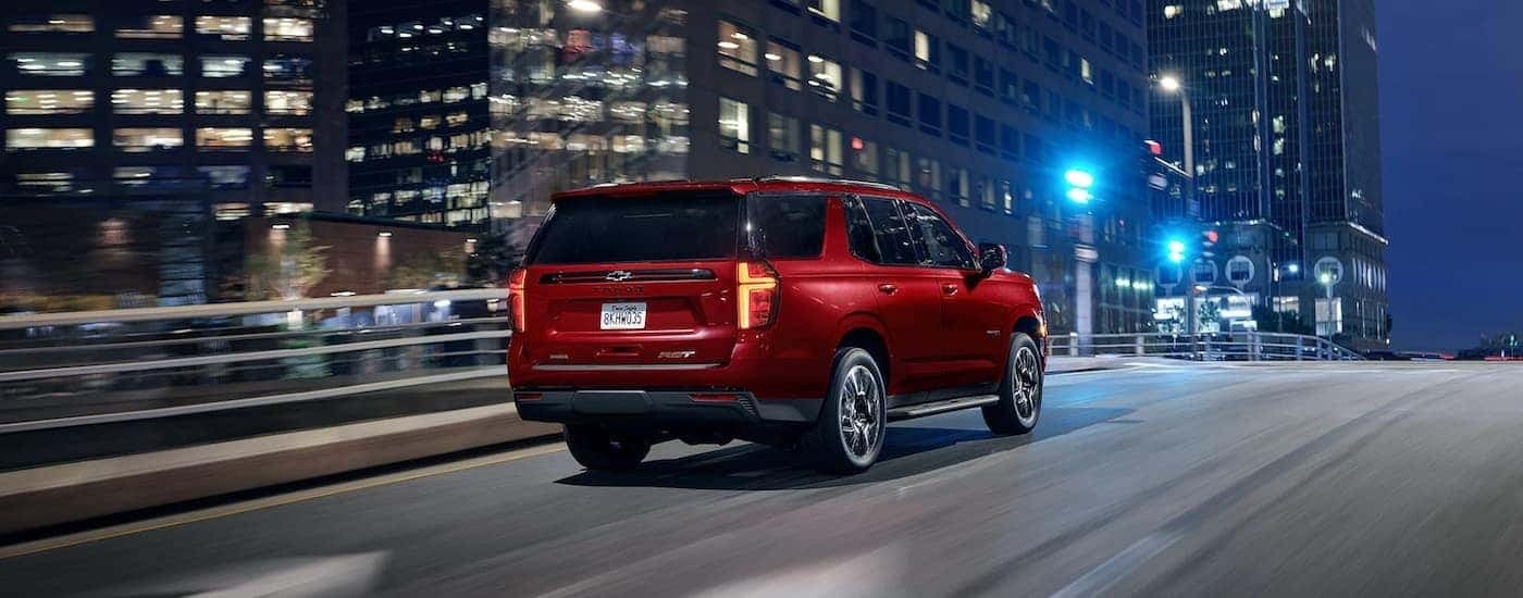 Red 2024 Chevy Tahoe driving through a city at night
